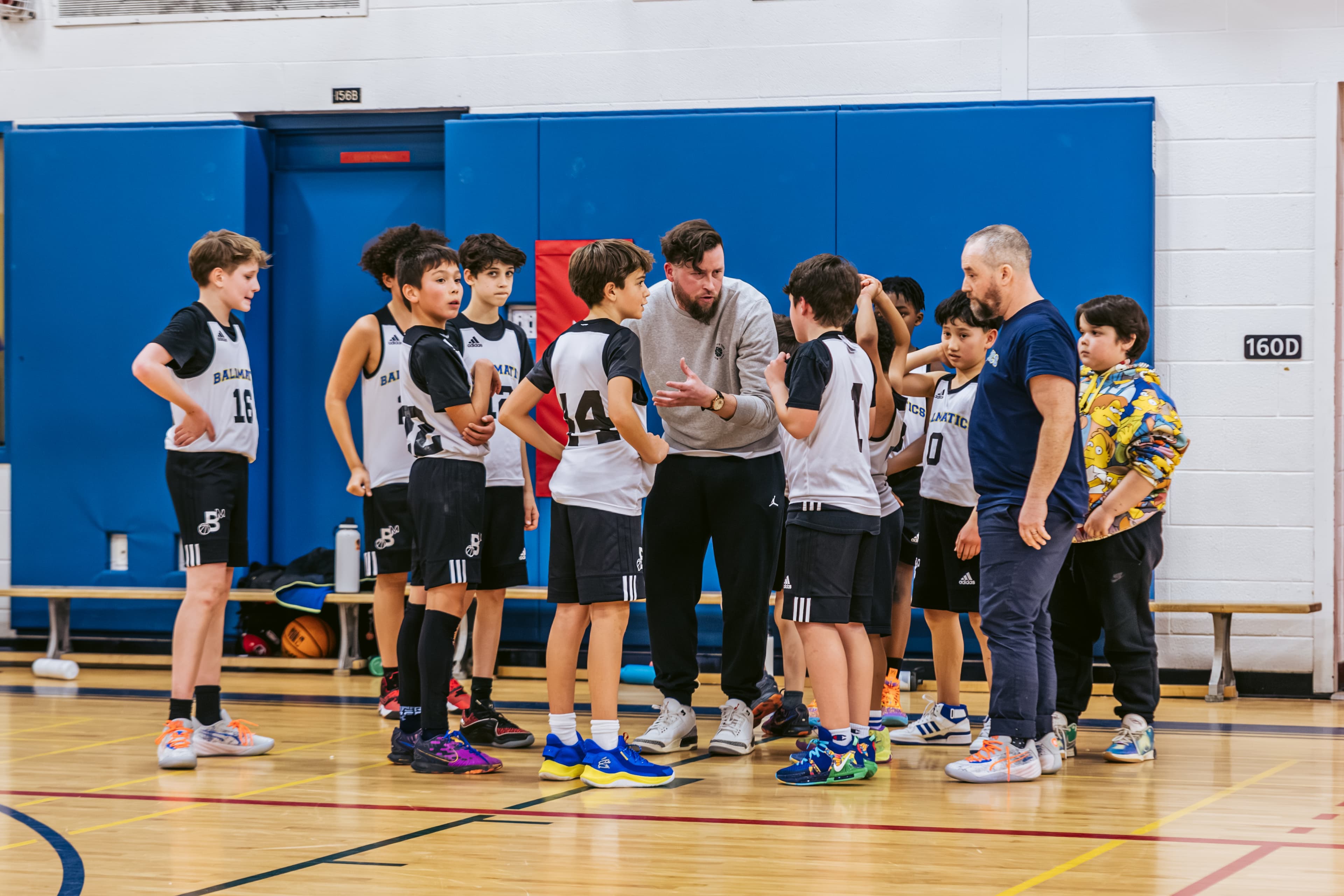 Coach Nolan talking with players in a huddle